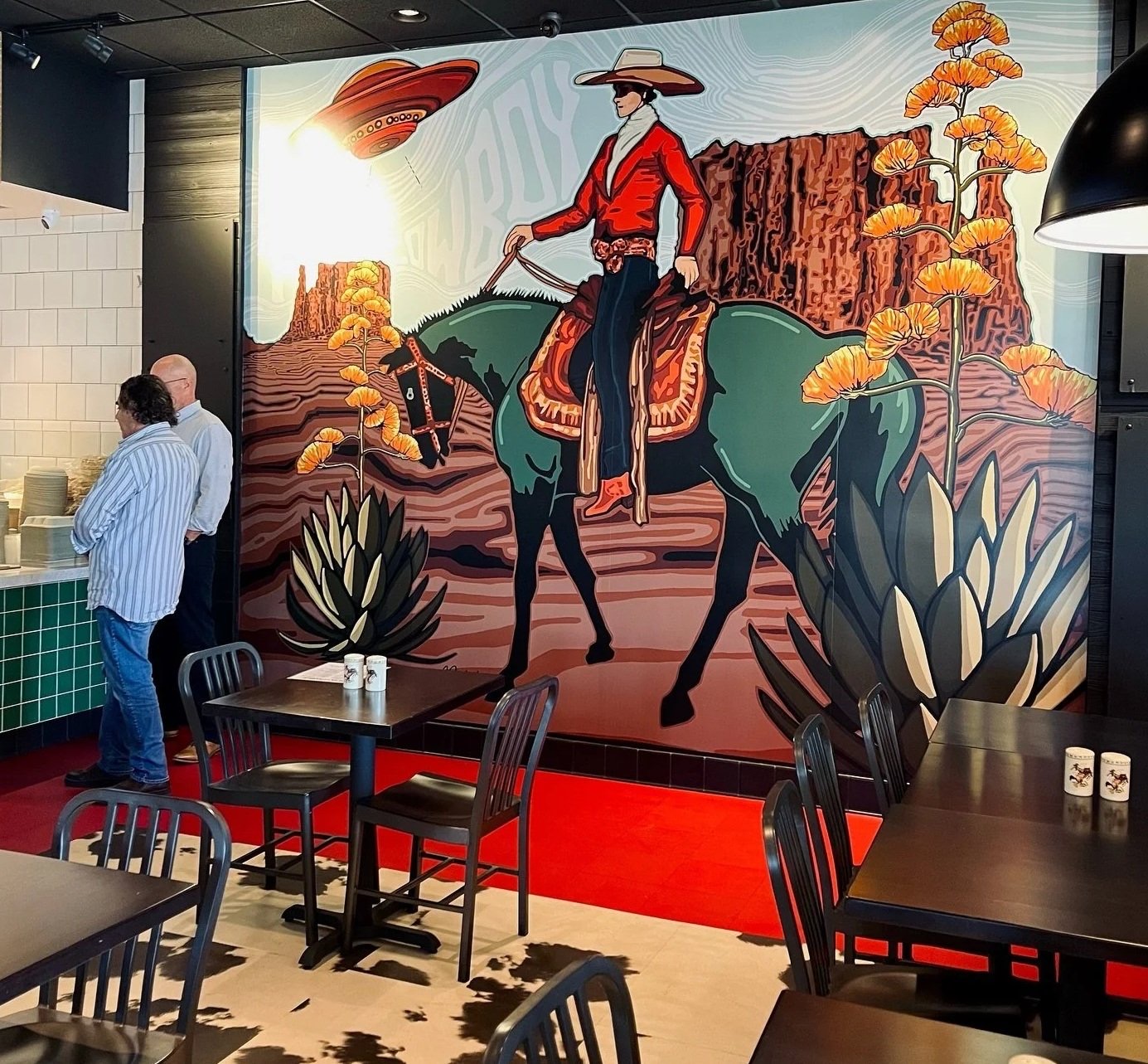 Hand-painted cowboy mural over the dining room at Feta Cowboy