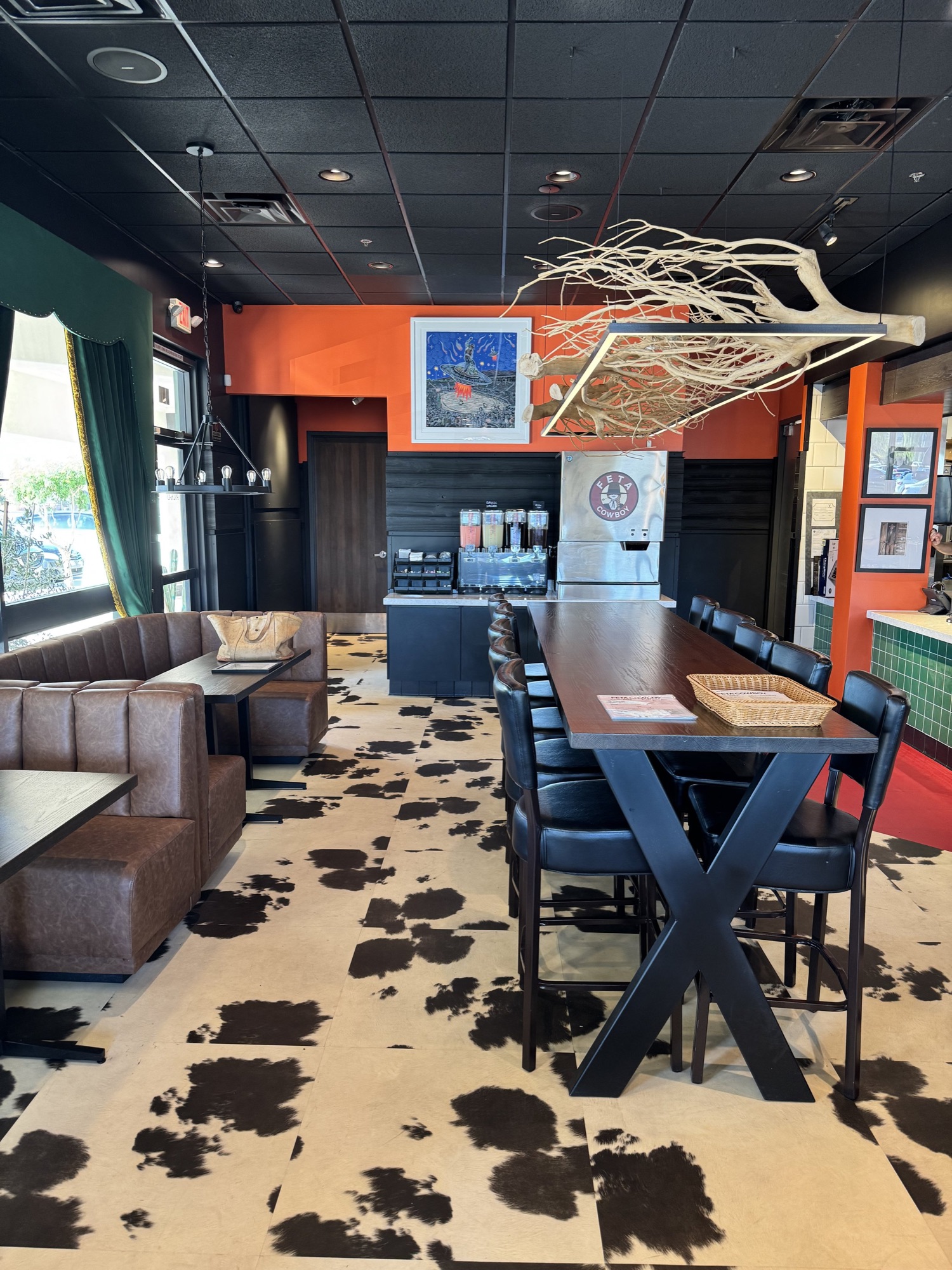 Cowhide-upholstered chairs at navy tables, Feta Cowboy