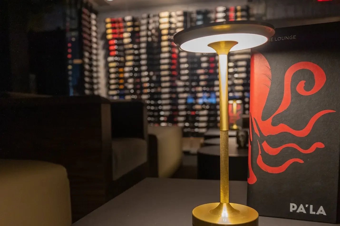 Brass table lamp in front of red octopus artwork at Pa’La