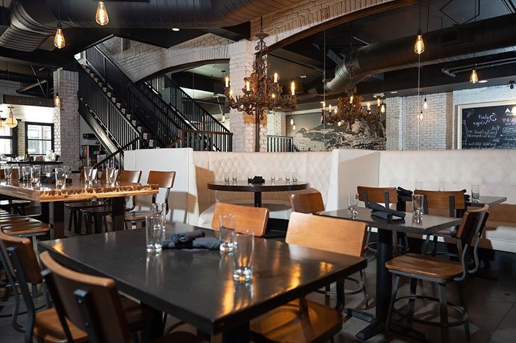 Dining room with iron chandeliers and an open stair at Pa’La