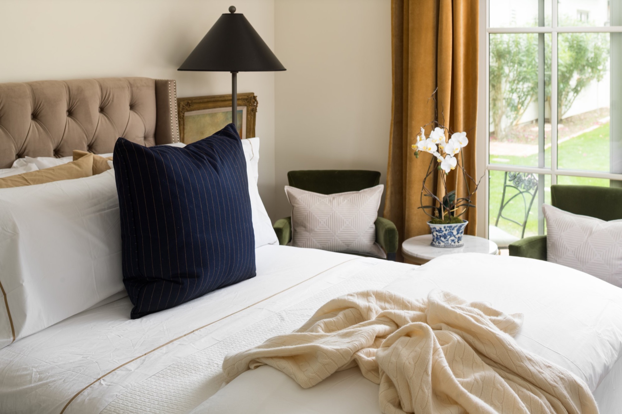 Bedroom with a tufted headboard and linen bedding